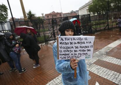 Una mujer con un cartel participa junto a miles de personas que asisten a la marcha.