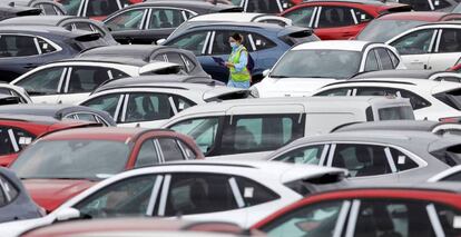 Una trabajadora de Ford camina entre automóviles aparcados en el exterior de la planta en Almussafes (Valencia).