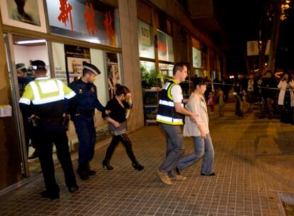 Agentes de la Guardia Urbana detienen a dos jóvenes de nacionalidad china que trabajan en una peluquería de Barcelona.