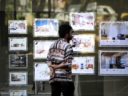 Un hombre mira anuncios de pisos en el escaparate de una inmobiliaria de Barcelona, en agosto.