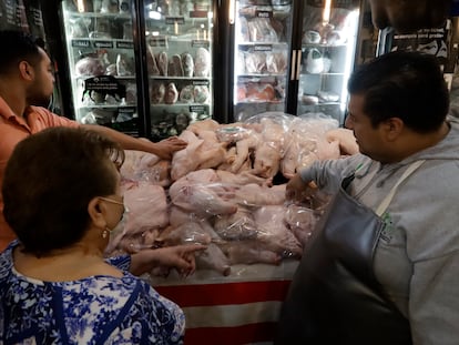 Una mujer compra ingredientes para su cena de Navidad, en el mercado de San Juan en Ciudad de México.