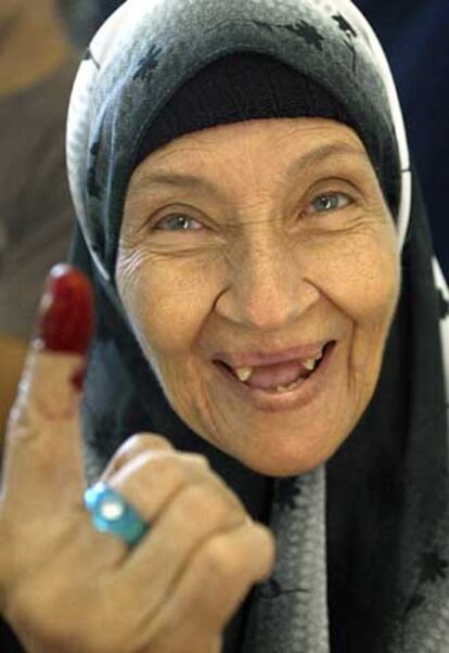 Una mujer muestra su dedo tintado tras votar ayer por Mubarak.