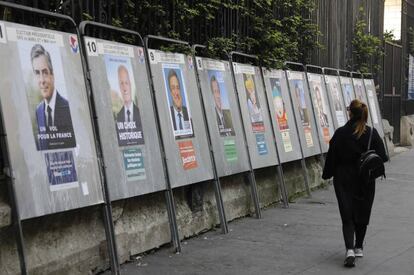 Una mujer pasa delante de los carteles de los candidatos de las elecciones presidenciales francesas en Par&iacute;s. 