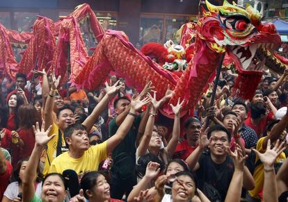Asistentes a la celebración del inicio del año de la cabra en el barrio chino de Manila (Filipinas), tratan de coger los caramelos y dulces que lanza el cortejo que acompaña a los bailarines de la danza del León.