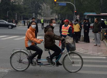 Una pareja china pasa ante el hotel de Pekín se reúnen los líderes.