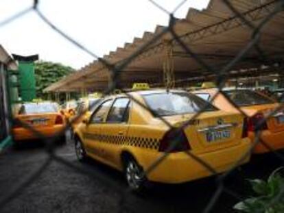 Decenas de taxis estatales permanecen en un estacionamiento, por una céntrica calle de La Habana (Cuba).