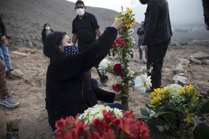 Fabiola Jaiker, de 27 años, decora una cruz con flores para la tumba de su abuela Vicenta Panduro Panduro, de 87 años, durante su entierro en Carabayllo. El presidente de Perú, Martín Vizcarra, ha anunciado el pasado jueves que el Gobierno ya se encuentra negociando con seis laboratorios para adquirir unas 30 millones de vacunas contra la covid-19. Vizcarra ha explicado que estas vacunas, cuya entrega se llevaría a cabo entre finales de 2020 y el primer trimestre de 2021, "tienen características especiales", pues deben mantenerse "a 20 y 80 grados bajo cero".