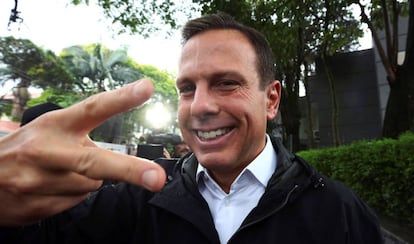 Prefeito eleito, Doria faz sinal de acelera, símbolo de sua campanha