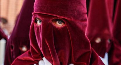 A penitent of the brotherhood of Cerro del Águila waits before the procession in the streets of Seville on April 16, 2019.