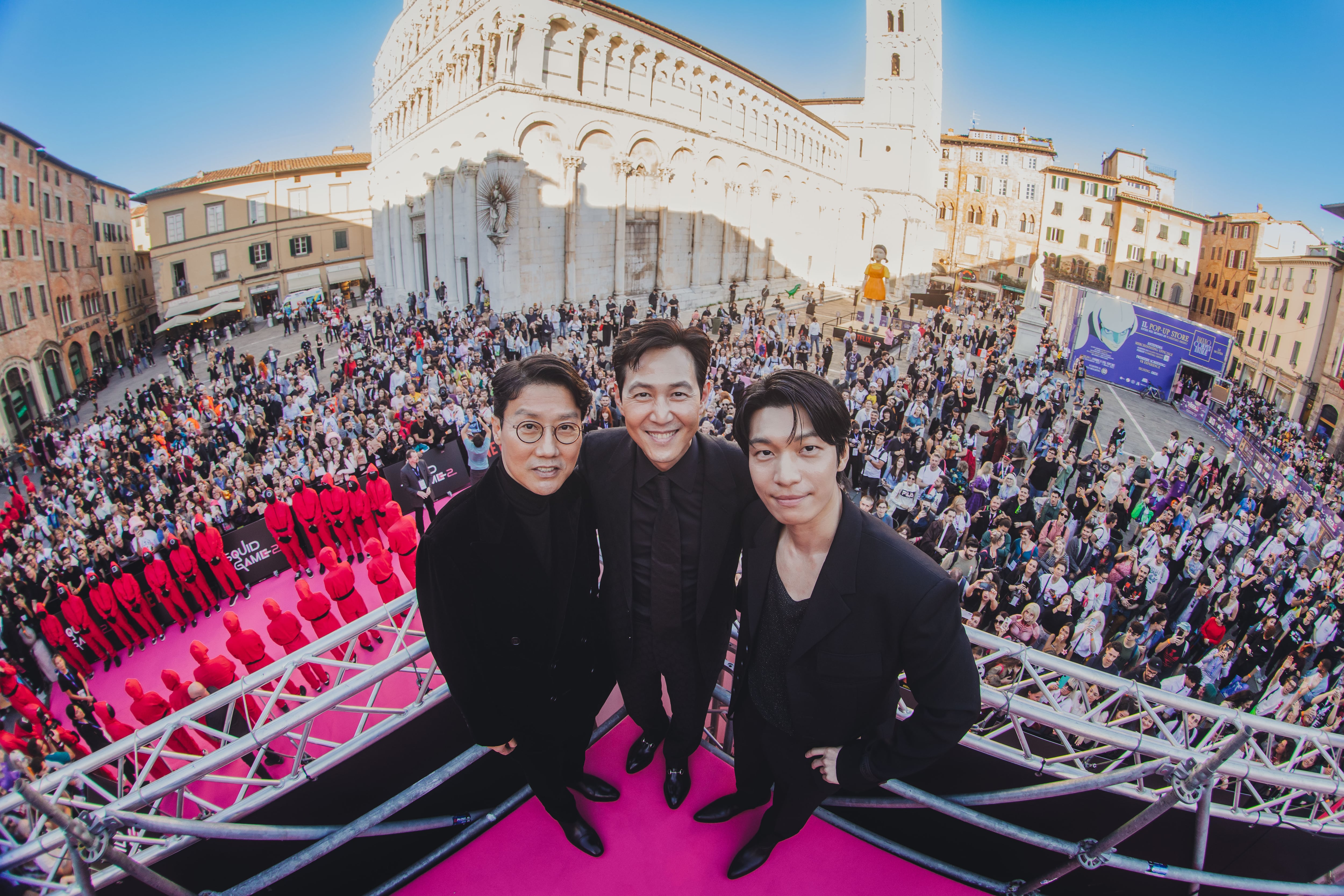 Desde la izquierda, Hwang Dong-hyuk, Lee Jung-jae y Wi Ha-joon, creador y actores de 'El juego del calamar', en la Piazza de San Michele de Lucca (Italia), durante la presentación de la segunda temporada, el 31 de octubre.