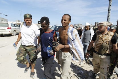 Combatientes anti-Gadafi detienen a un supuesto leal al dictador en Sirte.