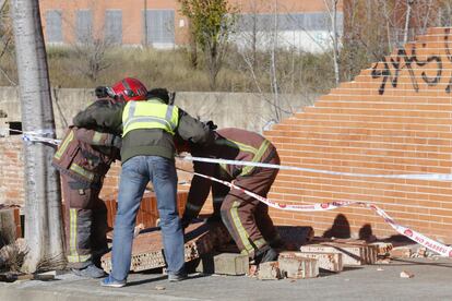 Los bomberos trabajan en la zona donde ha caído el muro a causa del vendaval, en Terrassa (Barcelona).