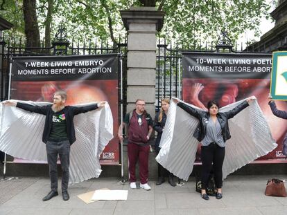 Ativistas pelo 'sim' tentam tampar cartazes contra o aborto em Dublin.