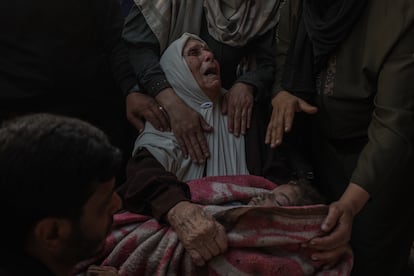 Una anciana llora sobre el cadáver de un niño muerto tras un bombardeo israelí sobre una escuela en Ciudad de Gaza, este lunes.