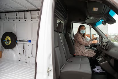 Miriam Ballesteros, alumna de la Escuela de Repartidores de España en Coslada (Madrid), posa dentro de una furgoneta de reparto eléctrica.
