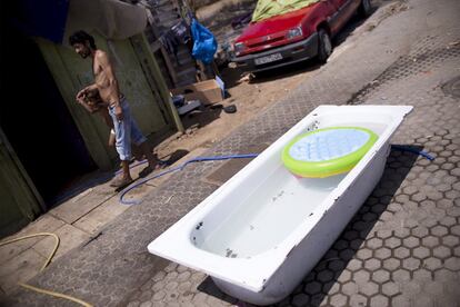 Pedro, en la puerta de su chabola junto a una bañera llena de agua, en el asentamiento chabolista de El Vacie en Sevilla.