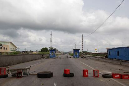 Cajas y neumáticos bloquean una de las autopistas que conectan Abiyán con el norte de país, en un puesto de control de las fuerzas de Ouattara.