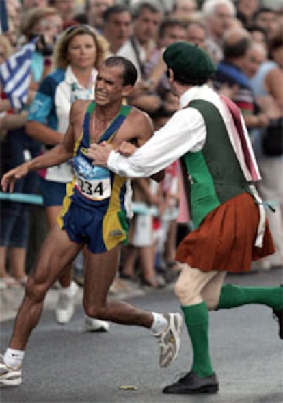 El brasileño Vanderlei Lima sufre la agresión de un espontáneo cuando lideraba la maratón.