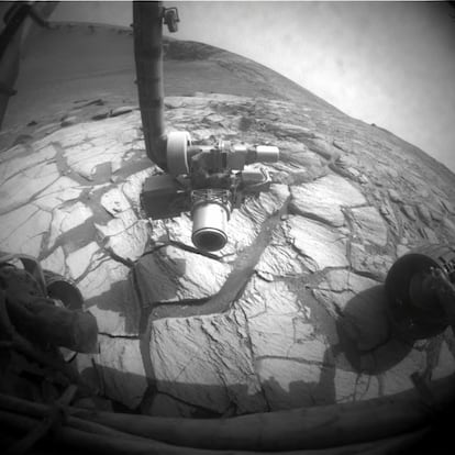El brazo articulado del 'Opportunity' con instrumentos de análisis explora una superficie rocosa en Marte.