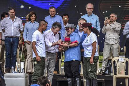 Una pareja de combatientes entrega una niña recién nacida, símbolo de paz, a Santos y Timochenko. 