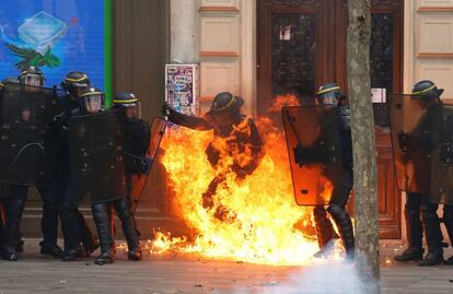 Varios agentes rodeados de llamas durante la manifestación contra la ley laboral, en París.