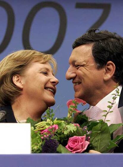José Manuel Durão Barroso entrega un ramo de flores a Angela Merkel al final de la cumbre europea.