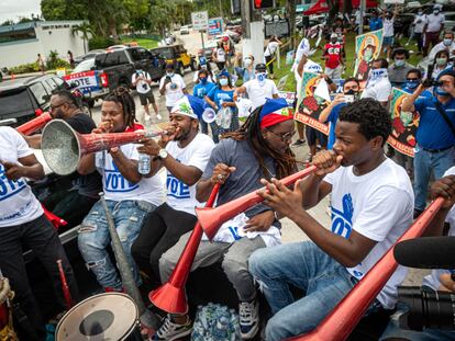 Unos jóvenes tocan música a la llegada del autobús La libertad en Miami, Florida.