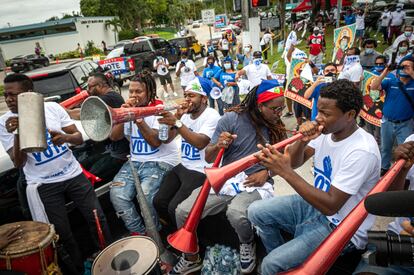 Unos jóvenes tocan música a la llegada del autobús La libertad en Miami, Florida.