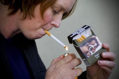 Una dona encenent una cigarreta.
