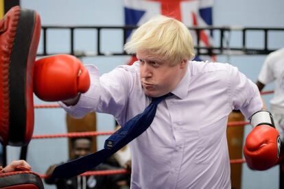 Boris Johnson, en su segundo período como alcalde de Londres, boxea con un entrenador durante su visita a la Academia 'Lucha por la Paz' en North Woolwich (Reino Unido), el 28 de octubre de 2014.