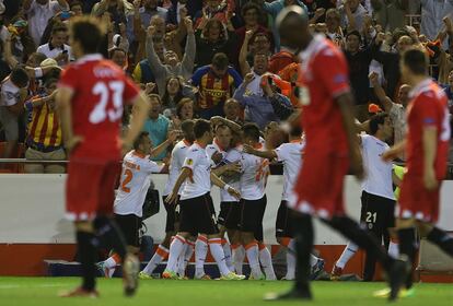 Los jugadores del Valencia celebran un gol ante la desolación sevillista.