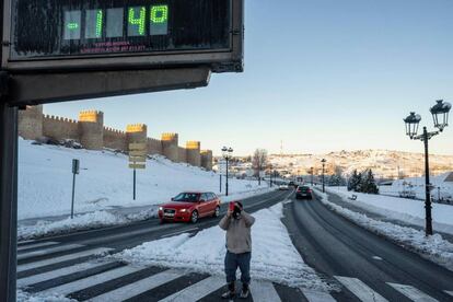 Un hombre toma una fotografía con su móvil de un termómetro que marca 14 grados bajo cero, este martes junto a la muralla de Ávila. La temperatura más baja de la red de estaciones automáticas de Aemet se medía a las nueve de la mañana en la localidad turolense de Bello, donde los termómetros han caído a unos siderales -25,4 ºC, seguida de Molina de Aragón (Guadalajara), con -25,2 ºC, y de Santa Eulalia del Campo (Teruel), con -23 ºC.