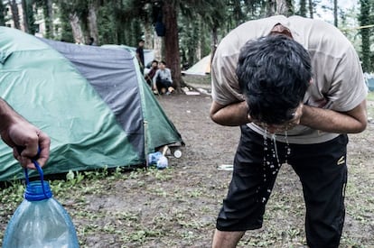 Dos kurdos iraquíes se lavan antes de cocinar. Pese a la instalación de baños y duchas, muchos migrantes y refugiados en Bihac y Velika Kladusa se lavan con agua embotellada.