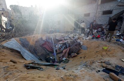 Palestinos inspeccionan el lugar donde una cohete israelí a destruido una vivienda, este miércoles en Rafah. 