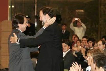 José María Aznar y Mariano Rajoy se saludan ayer en el acto organizado ayer por FAES.