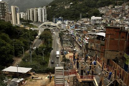 Obreros trabajan justo donde termina la favela la Rocinha y comienzan los bloques de apartamentos de Río de Janeiro.