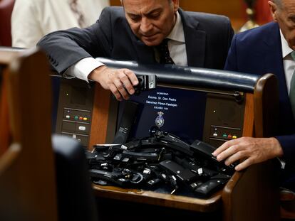 Los diputados de Vox abandonan el pleno del Congreso y dejan sus auriculares en el escaño de Pedro Sánchez.