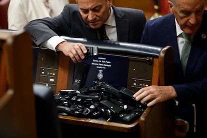 Los diputados de Vox abandonan el pleno del Congreso y dejan sus auriculares en el escaño de Pedro Sánchez.