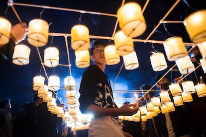 Un hombre enciende pequeñas linternas conectadas a un globo aerostático durante el Festival de Iluminación de Tazaungdaing, en Taunggyi (Myanmar).