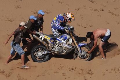 Joan Viladoms gets some help to get his motorbike over a dune in the Atacama.