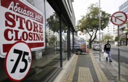 Un viandante pasa delante de una tienda que anuncia su cierre en la avenida Makarios, el que fuera el corazón comercial de Nicosia (Chipre). EFE/Archivo