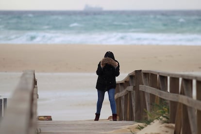Una mujer intenta caminar por la playa de los Lances en Tarifa (Cádiz), que está siendo azotada por las fuertes rachas de viento generadas por la borrasca Bruno que recorre desde ayer la Península y que ha provocado en la comunidad andaluza numerosas incidencias, el 27 de diciembre.