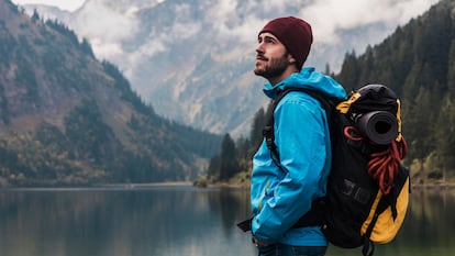 Hombre haciendo senderismo en invierno y mirando el paisaje.