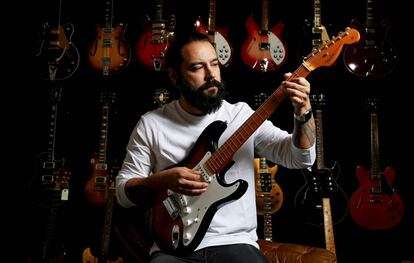 Israel Domínguez, toca una guitarra en su tienda HeaDBanger Rare Guitars, en Madrid.