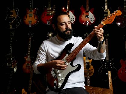 Israel Domínguez, toca una guitarra en su tienda HeaDBanger Rare Guitars, en Madrid.