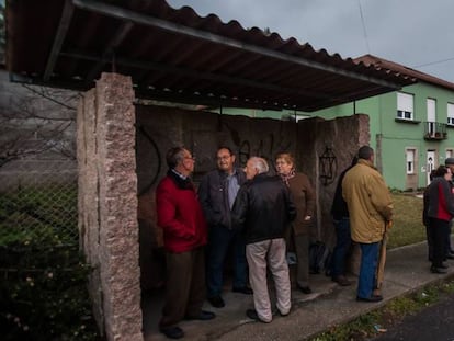 Vecinos de Tarago (Rianxo), observan desde la parada del bus la casa del detenido por la desaparici&oacute;n de Diana Quer.