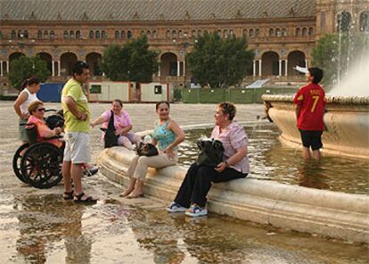 Varios turistas se refrescaban a media tarde de ayer en la fuente de la Plaza de España.