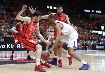 Los jugadores del Valencia Basket, Guillem Vuives (izqda) y Pierre Oriola (d. detrás), defienden al pívot estadounidense del Real Madrid Anthony Randolph, durante el cuarto partido de la final de la Liga ACB.