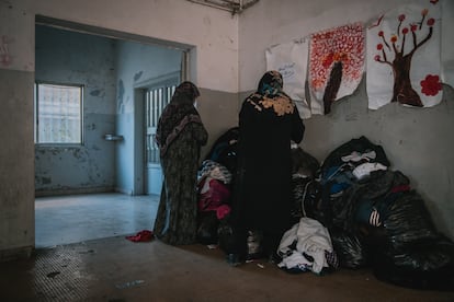 Two displaced women search for clothes in a donation bag at a school converted into a shelter in Aley, central Lebanon.