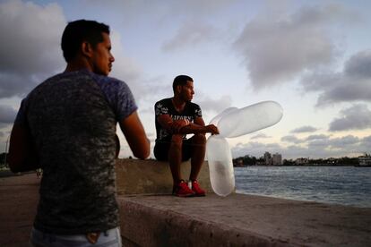 Alex Pérez, albañil de profesión, observa el mar mientras se prepara para lanzar condones inflados con anzuelos, usados como cebos para pescar en La Habana (Cuba).